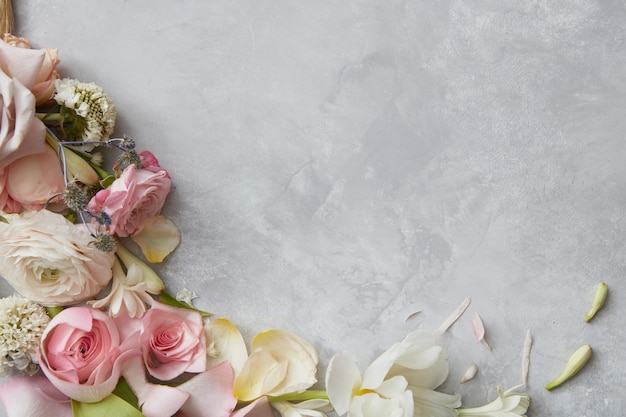 frame of flowers decorating grey background. top view of composition of white, pink roses designing grey background. b