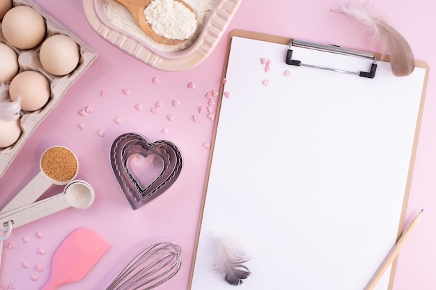 Frame of food ingredients for baking on a gently pink pastel surface