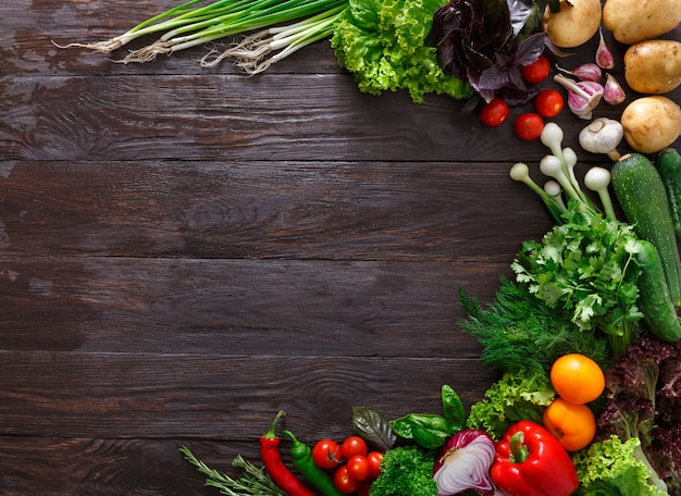 Cornice di verdure fresche su fondo in legno con copia spazio