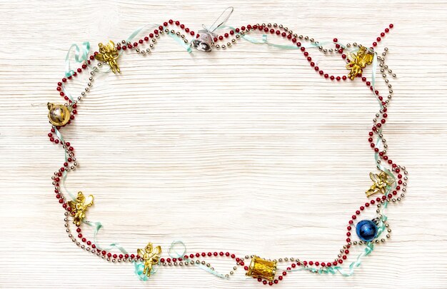 Frame from Christmas garlands and toys on wooden background