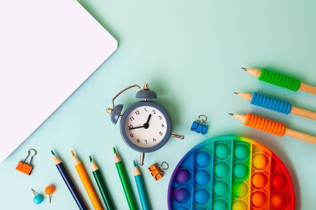 Frame from different school supplies on the blue background.Back to school concept,top view.