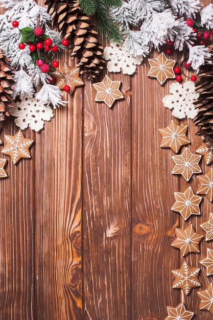 Frame of gingerbreads and winter decor on a wooden background.