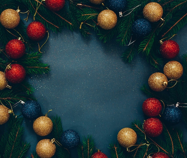 frame of green fir and Christmas decoration on a black background with empty space