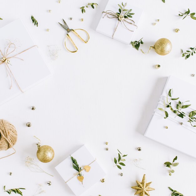 Рамка из рождественских подарочных коробок ручной работы и праздничное украшение на белом фоне. Плоская планировка, вид сверху
