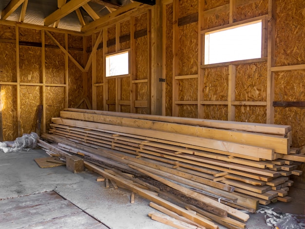 Frame house made of timber. Lumber in the pile