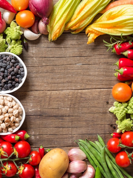 Frame made of chickpea in bowls with vegetables on a wooden table with copy space top view