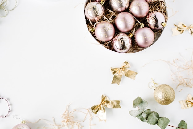 Frame made of christmas decoration with christmas glass balls, tinsel, bow, eucalyptus.