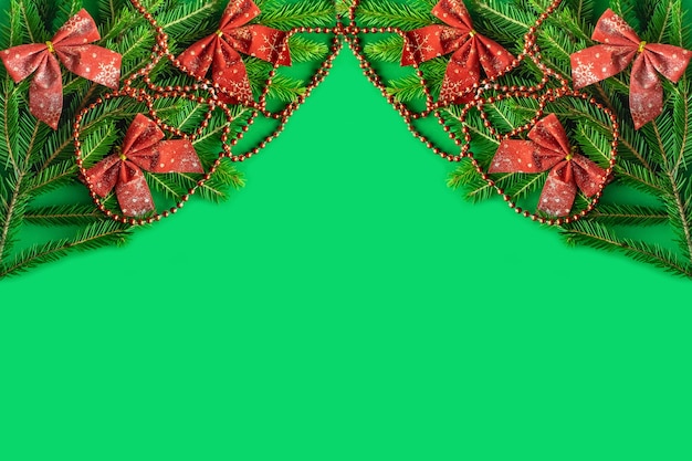 Frame made of christmas decorations on green background, top view with space for text