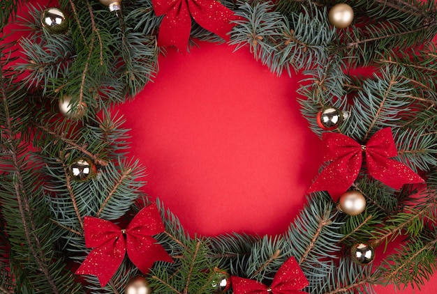 Frame made of Christmas decorations on red background, top view with space for text. Winter season.