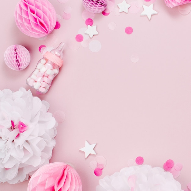 Photo frame made of decorative baby milk bottles with candy and paper decorations for baby shower party. flat lay, top view