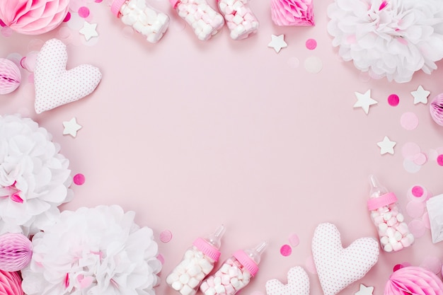 Frame made of Decorative Baby milk bottles with candy and paper decorations for Baby shower party. Flat lay, top view