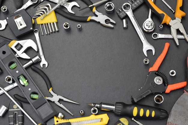 frame made of Handyman tool kit on black wooden table, top view