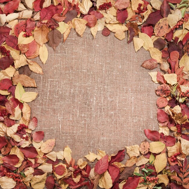 黄麻布の背景、秋のテーマの葉で作られたフレーム