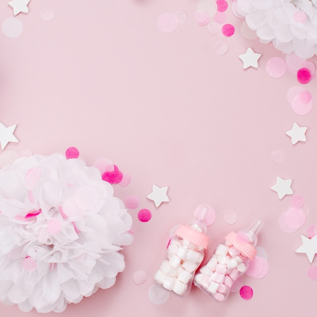 Фото Каркас из декоративных бутылочек для детского молока с конфетами и бумажными украшениями для вечеринки baby shower. плоская планировка, вид сверху