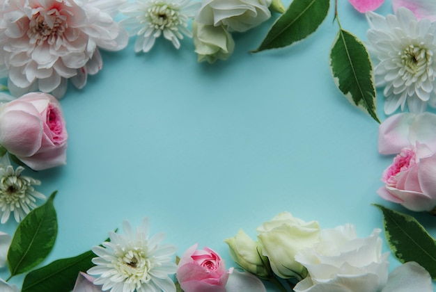 Frame made of pink flowers on pastel blue background