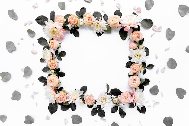 Frame made of pink roses green leaves eucalyptus branches floral pattern on white background flat la