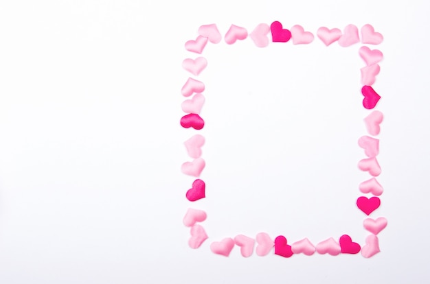 Photo frame made of small pink hearts on the white background