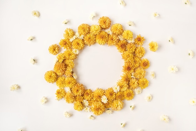 Frame made of yellow wild flower buds on white background. Flatlay, top view