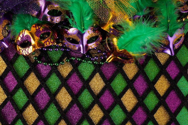Foto cornice di maschera mardi gras e perline colorate mardi gras su sfondo a forma di diamante