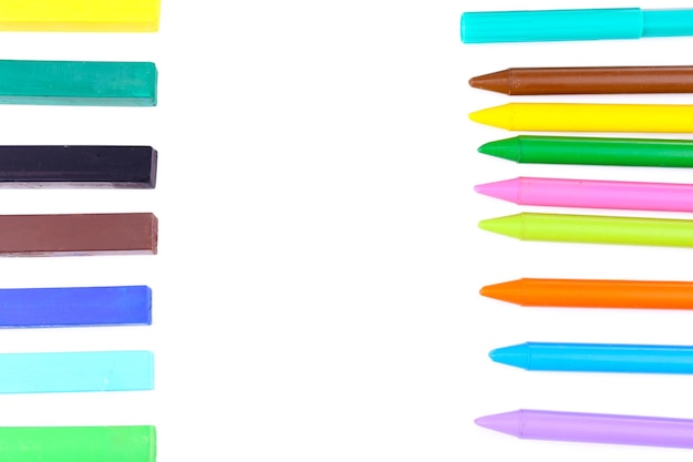 Foto frame met kleurrijke kleurpotloden en krijtpastelkleuren die op wit worden geïsoleerd