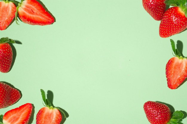 Frame met verse rode aardbeien, op een groene achtergrond.