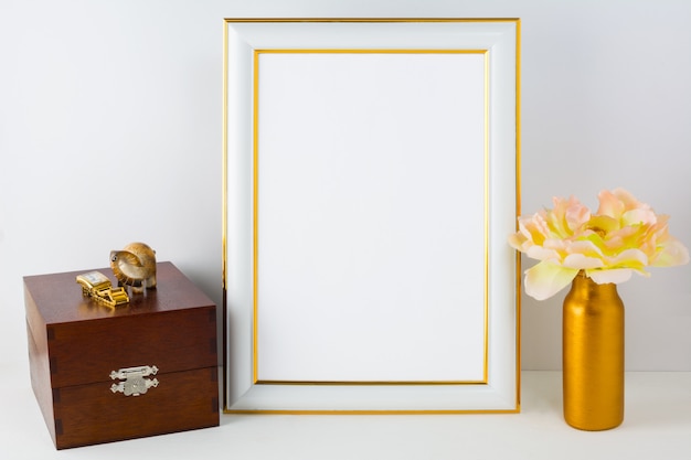 Frame mockup met houten kist en gouden vaas