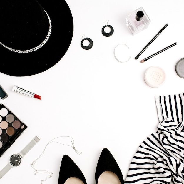 Photo frame of modern clothes, accessories and cosmetics. tshirt, hat, shoes, palette, lipstick, watches, powder on white background. flat lay, top view.