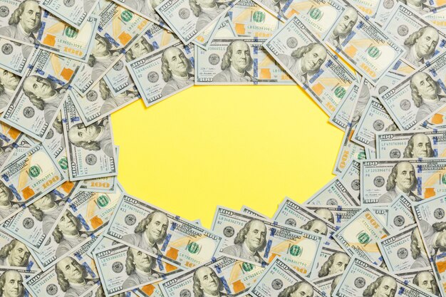 Frame of one hundred dollar bills. Top view of business concept on yellow background