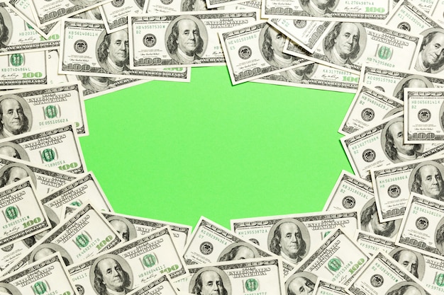 Frame of one hundred dollar bills with empty space r . Top view of business  on green  with copyspace