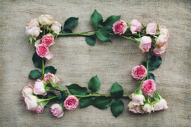 Frame of pink roses on burlap