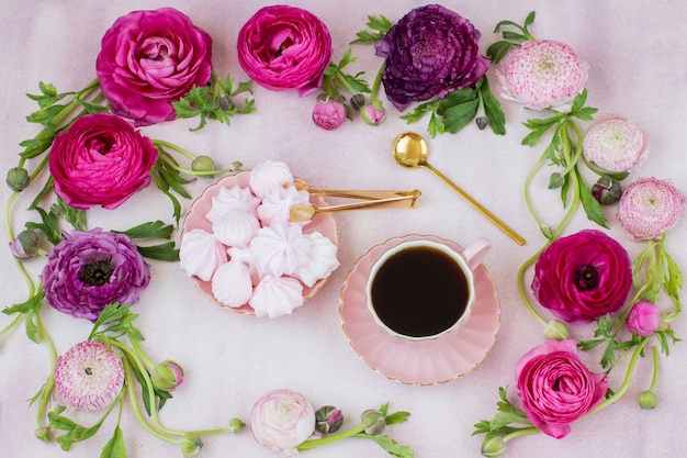 Una cornice di ranuncoli e meringa, una tazza di caffè