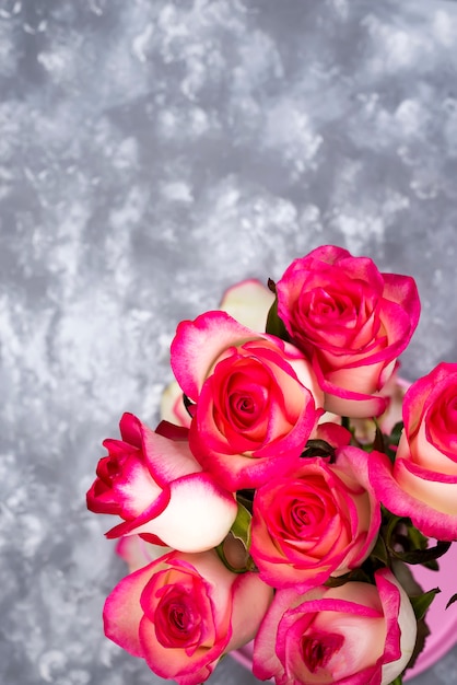 Frame of Red white rose flower bouquet on stone table.