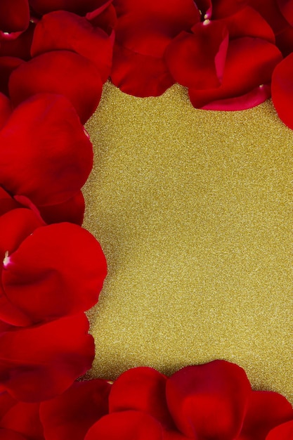 Frame of rose petals on golden background close-up