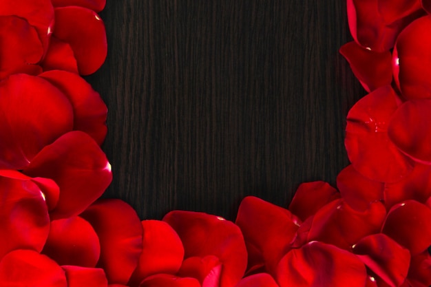 Frame of rose petals on wooden table close-up