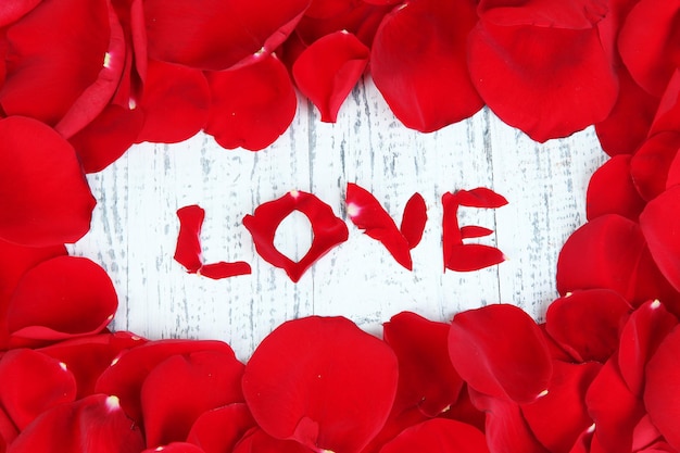 Frame of rose petals on wooden table close-up