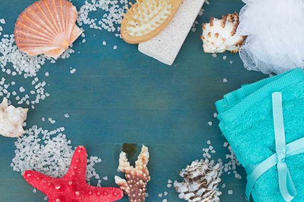 Frame of sea salt and shells on blue table