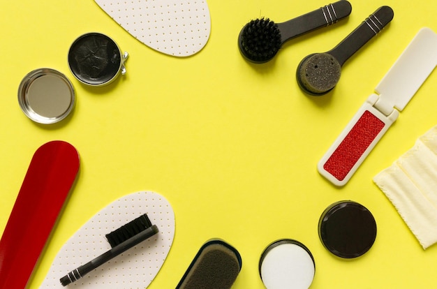 Photo frame of shoe care products cream and brushes on yellow background