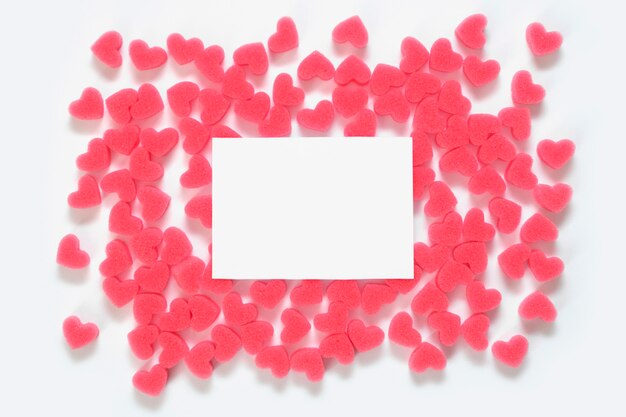 Frame of soft pink hearts on a white wallwith copy space.
