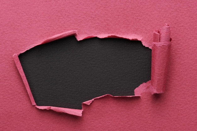 Frame van gescheurd papier met gescheurde randen Venster voor tekst met kopieerruimte zwart rood bordeaux kleuren flarden van notitieboekjepagina's abstracte achtergrond