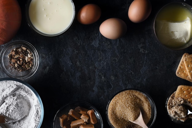 Frame van ingrediënten voor pompoen dump cake op de donkere stenen achtergrond bovenaanzicht