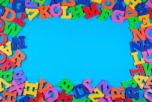 Foto frame van plastic kleurrijke alfabetletters op een blauwe achtergrond