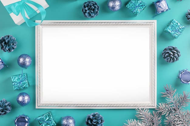 Frame with empty white space with Christmas decorations and gifts on a blue background. Postcard Merry Christmas and Happy New Year with free space for greeting texts.