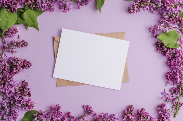 frame with lilac flowers on purple background