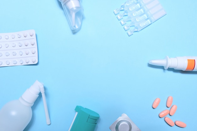 Frame with many pills and tablets on blue background