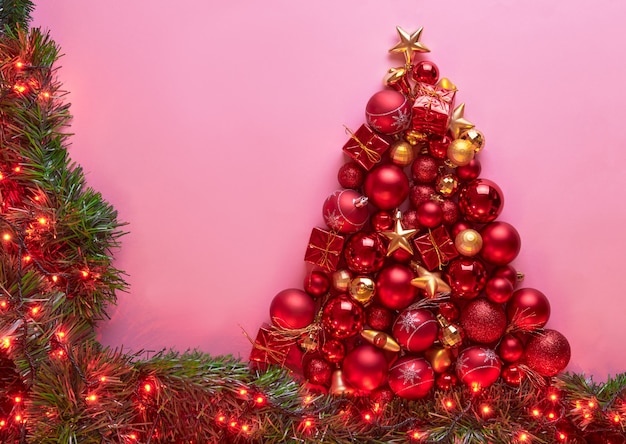 A frame with a red and gold color Christmas tree made with ornaments, balls and lights, poster