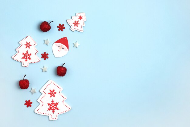 Frame with red and white christmas toys on blue paper 