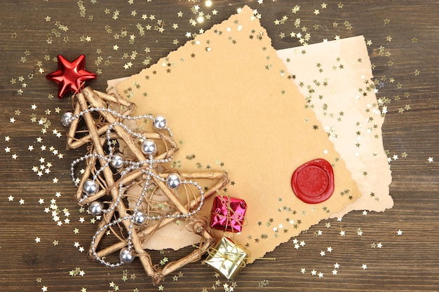 Frame with vintage paper and Christmas decorations on wooden background