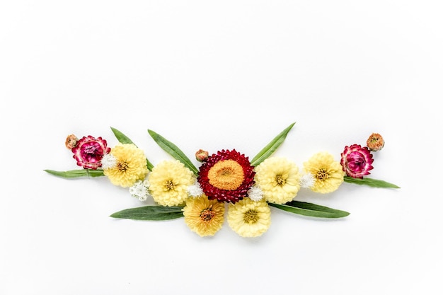 Frame yellow flowers branches leaves and petals isolated on white background flat lay overhead view