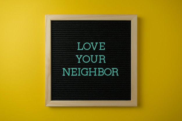 framed board with a slogan on a yellow wall photo