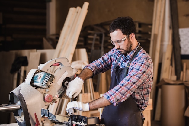 Framing contractor using a circular cut off saw to trim wood studs length.